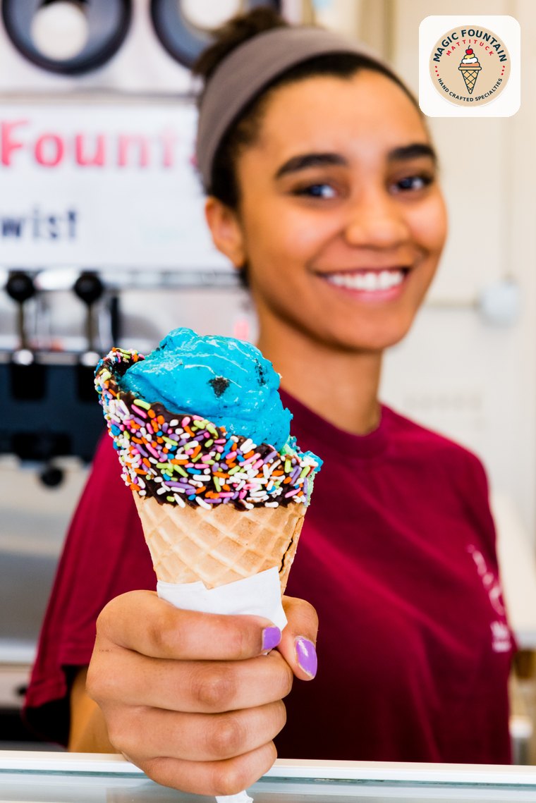 A Magic Fountain server holding a blue ice cream cone with rainbow sprinkles, Mattituck, NY